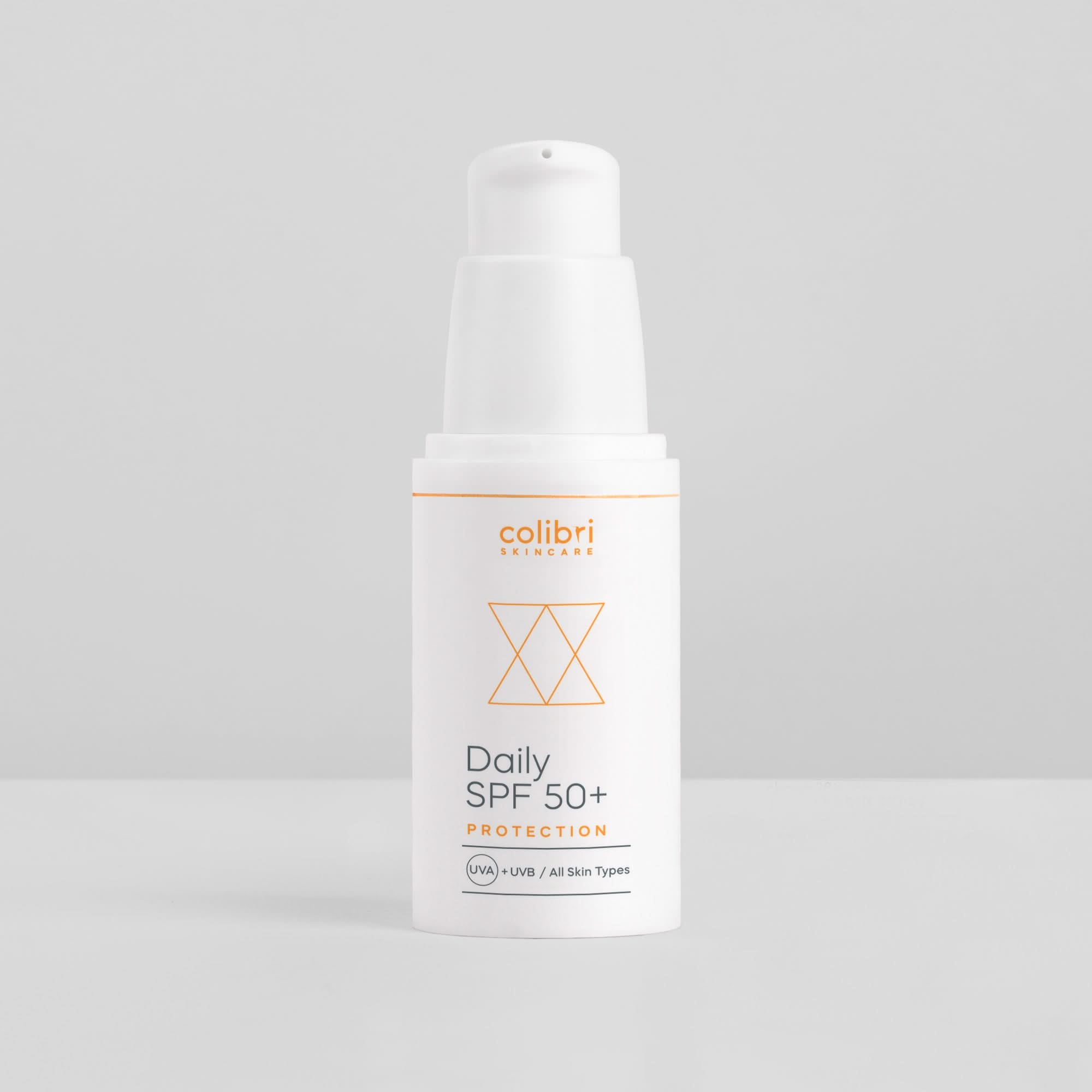 Weiße Flasche einer Sonnencreme mit der Aufschrift "Daily SPF 50+ Protection" auf grauem Hintergrund.