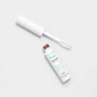 Flasche mit Wimpernbooster und Bürstenapplikator auf hellem Hintergrund, Etikett "Eyelash Booster".