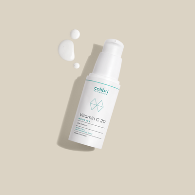 Flasche mit Vitamin C 20 Booster und Tropfen auf beigem Hintergrund.